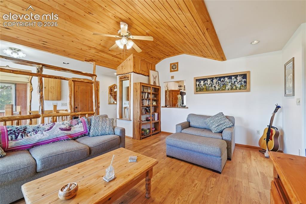 Image 9 of 49: Living room with natural wood vaulted ceiling