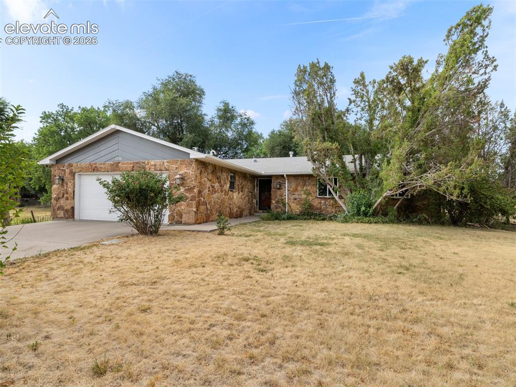 Image 2 of 35: Ranch-style residence featuring a stone veneer exterior, an attached garage