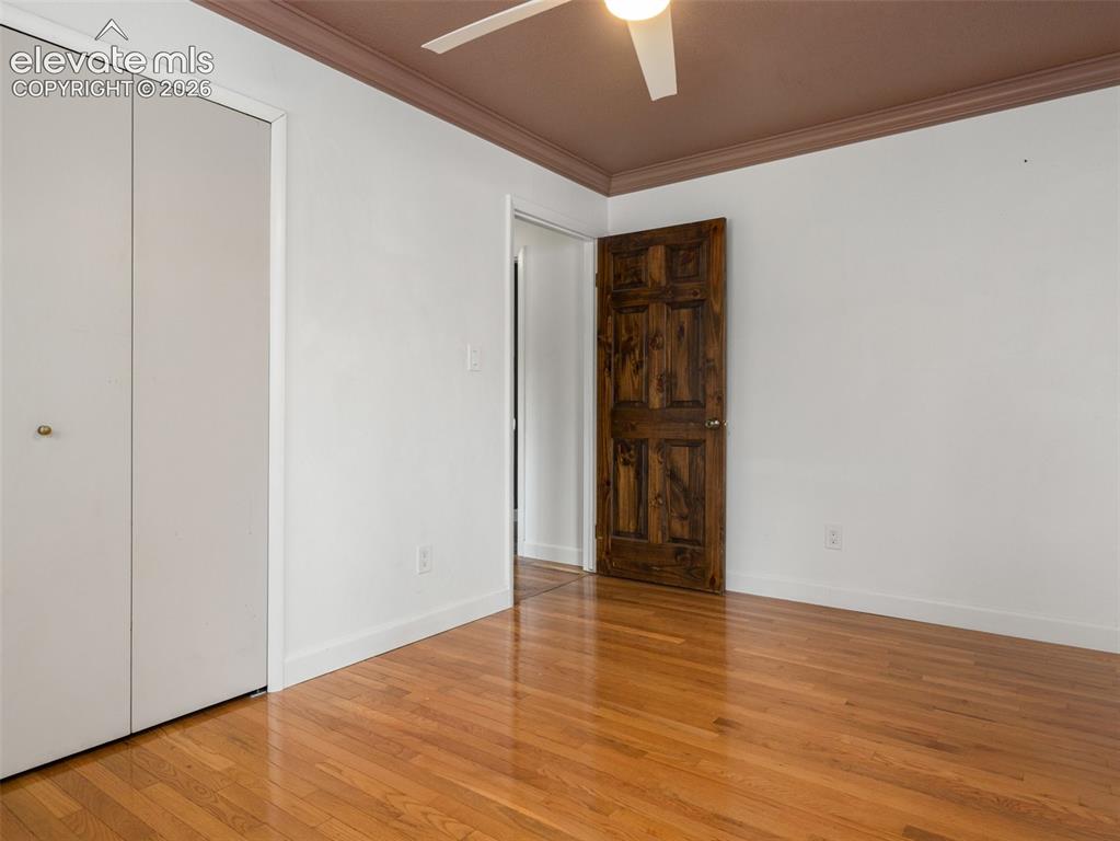 Image 23 of 35: Room featuring wood-finish flooring, white walls, and a ceiling fan