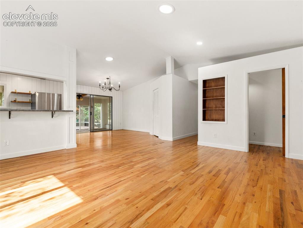 Image 4 of 35: Expansive living area featuring wood-finish flooring, recessed lighting, an