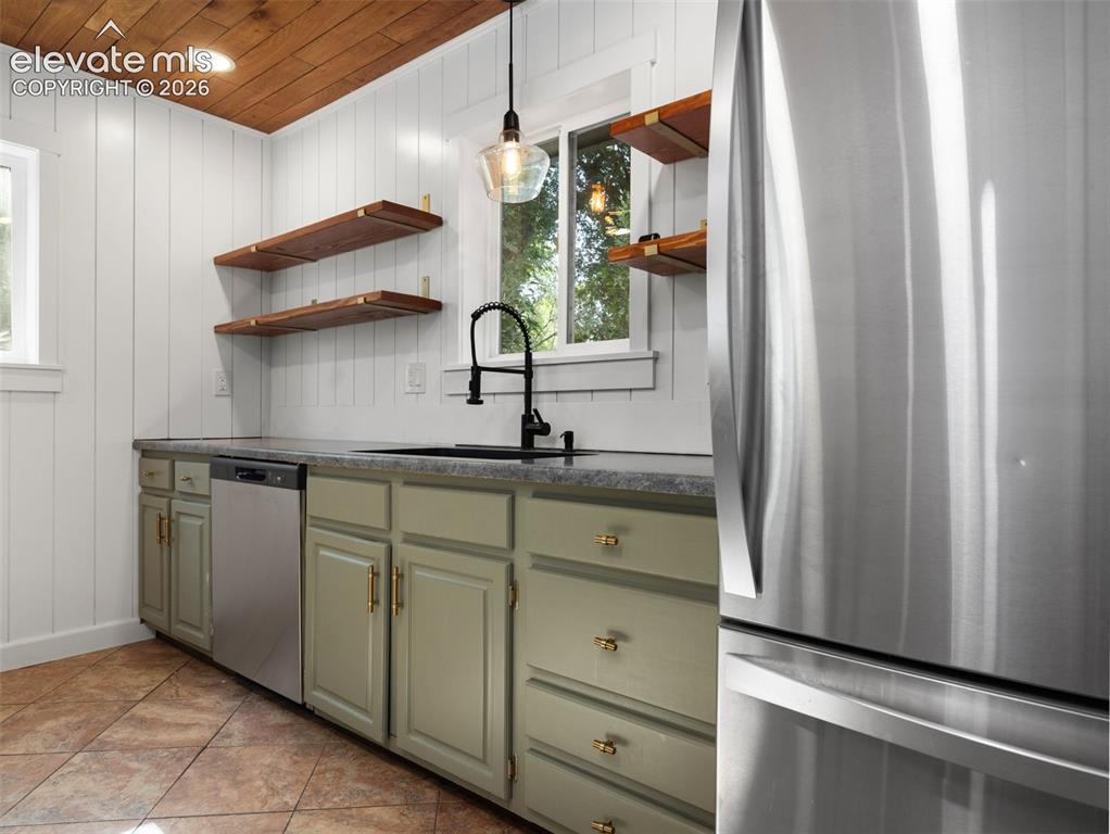 Image 9 of 35: Kitchen area featuring wood plank ceiling, white vertical paneling, sage gr