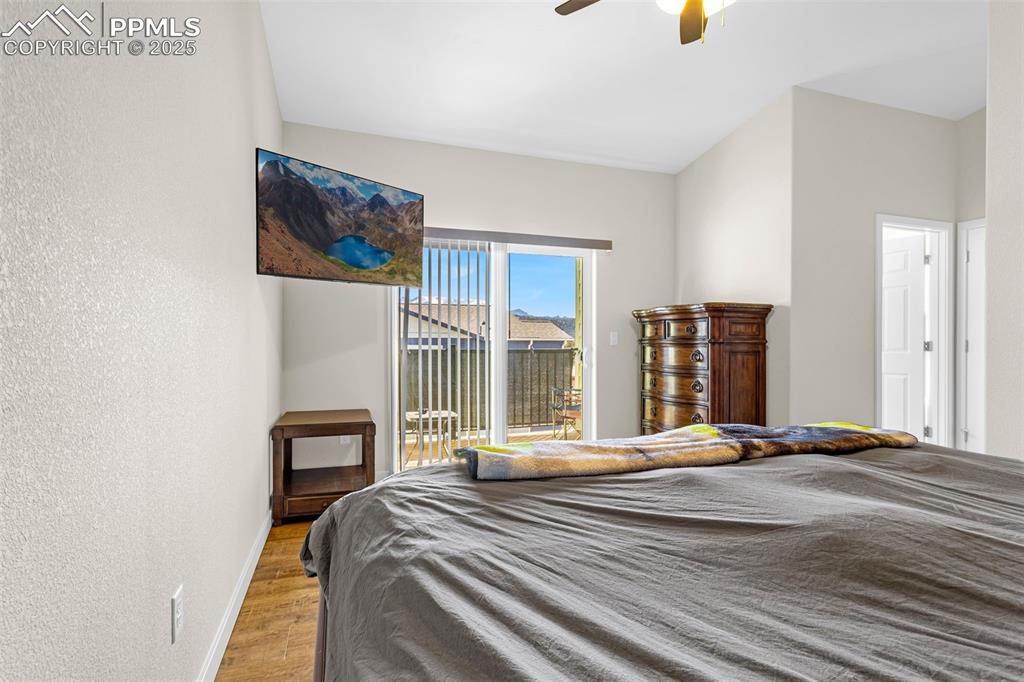 Image 14 of 37: Primary Bedroom with a ceiling fan, engineered hardwood floor, walk-out to