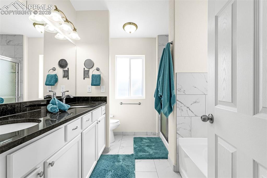 Image 17 of 37: Full bath featuring double vanity with granite counters, tile floor, tile s
