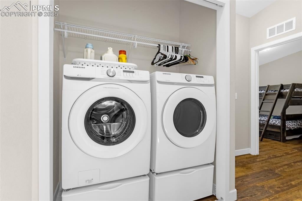 Image 20 of 37: Laundry area, washing machine and dryer, laundry area, and wood finished fl