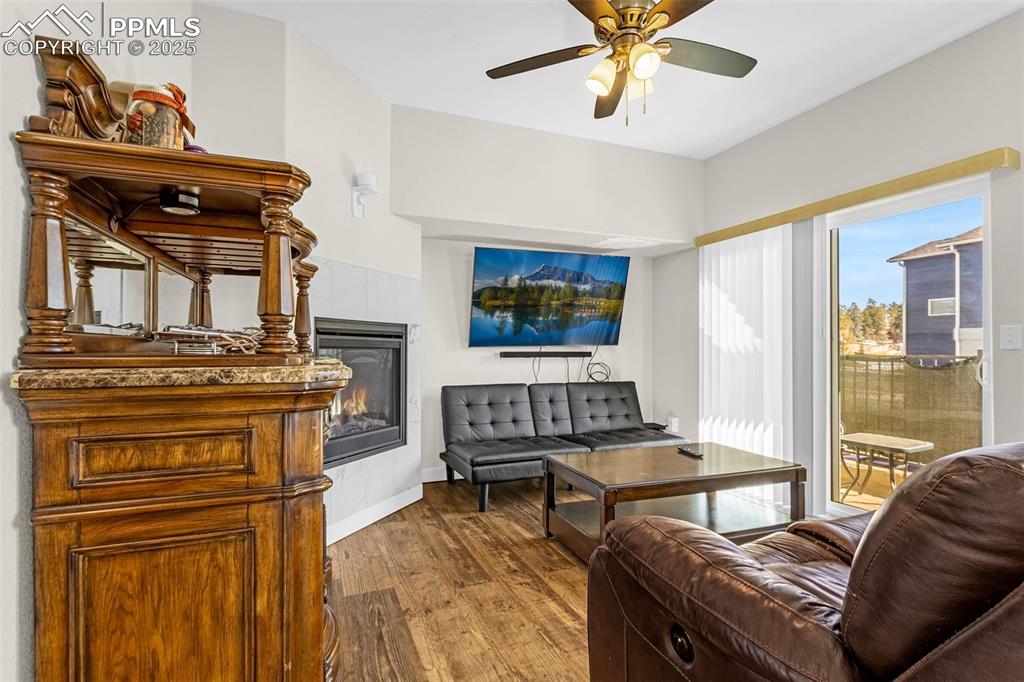 Image 5 of 37: Sitting room featuring a glass covered fireplace, wood finished floors, and
