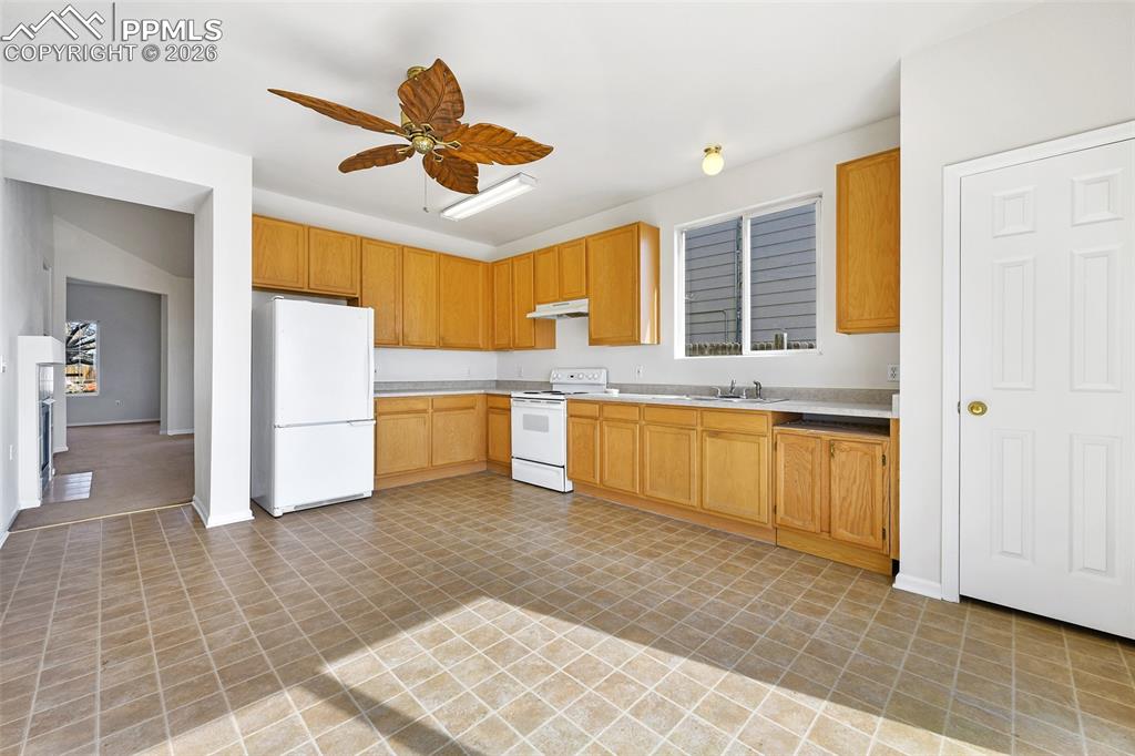 Image 12 of 28: Kitchen featuring white appliances, light countertops, and a ceiling fan
