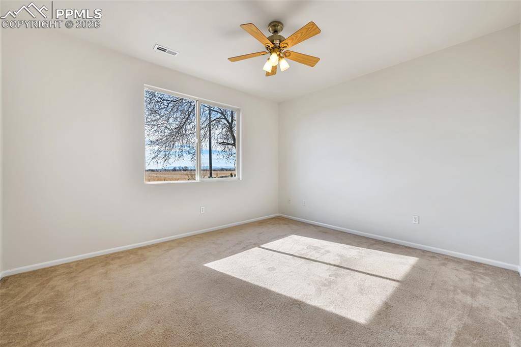 Image 17 of 28: Carpeted spare room with baseboards and a ceiling fan