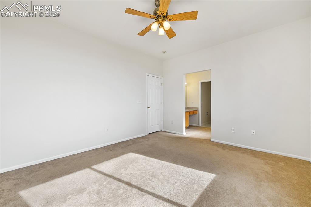 Image 18 of 28: Unfurnished bedroom with ensuite bathroom, carpet flooring, and a ceiling f