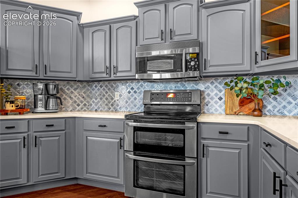 Image 10 of 41: Stunning quartz counters and tile backsplash