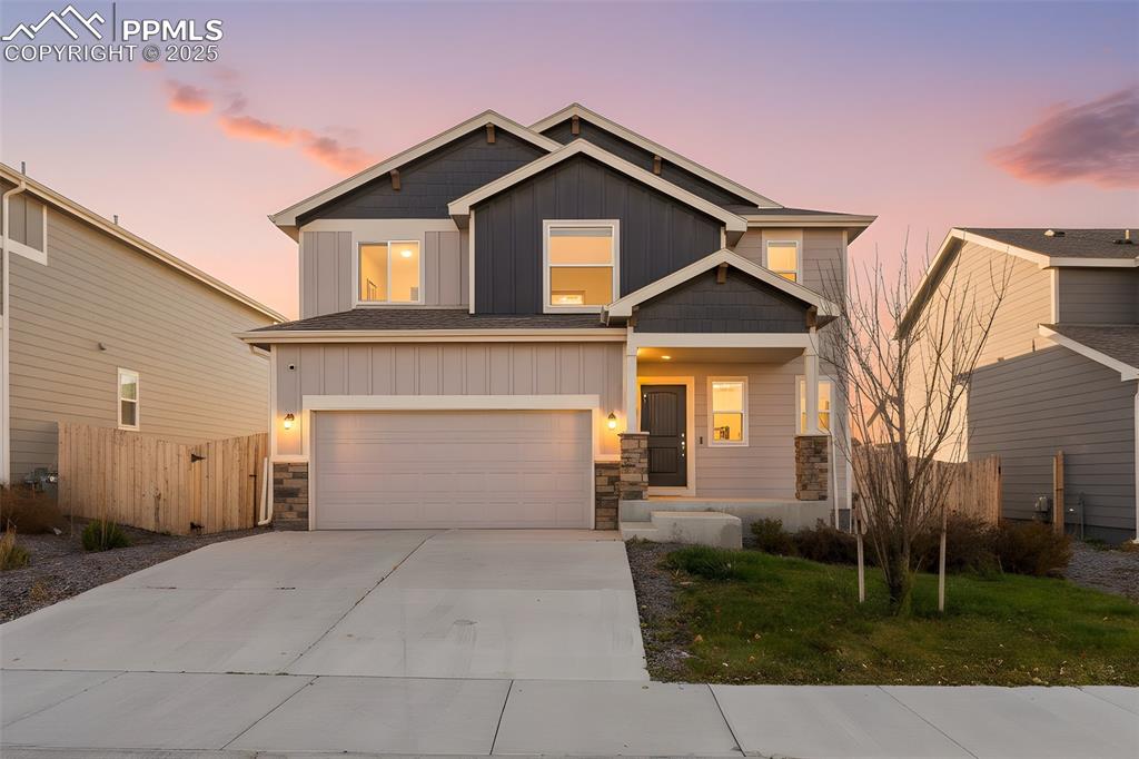 Image 13 of 48: Craftsman inspired home with stone siding, board and batten siding, drivewa