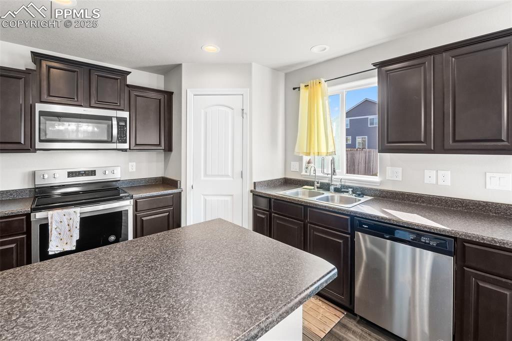 Image 25 of 48: Kitchen with dark countertops, appliances with stainless steel finishes, da