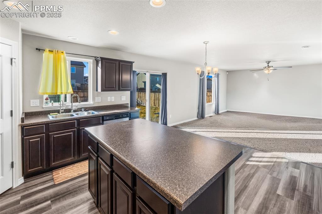 Image 29 of 48: Kitchen featuring dark brown cabinets, dark countertops, a chandelier, a ce