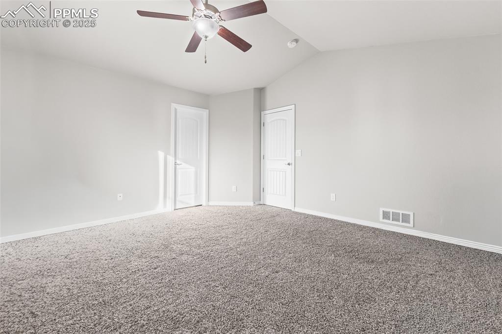 Image 34 of 48: Carpeted spare room featuring lofted ceiling and ceiling fan