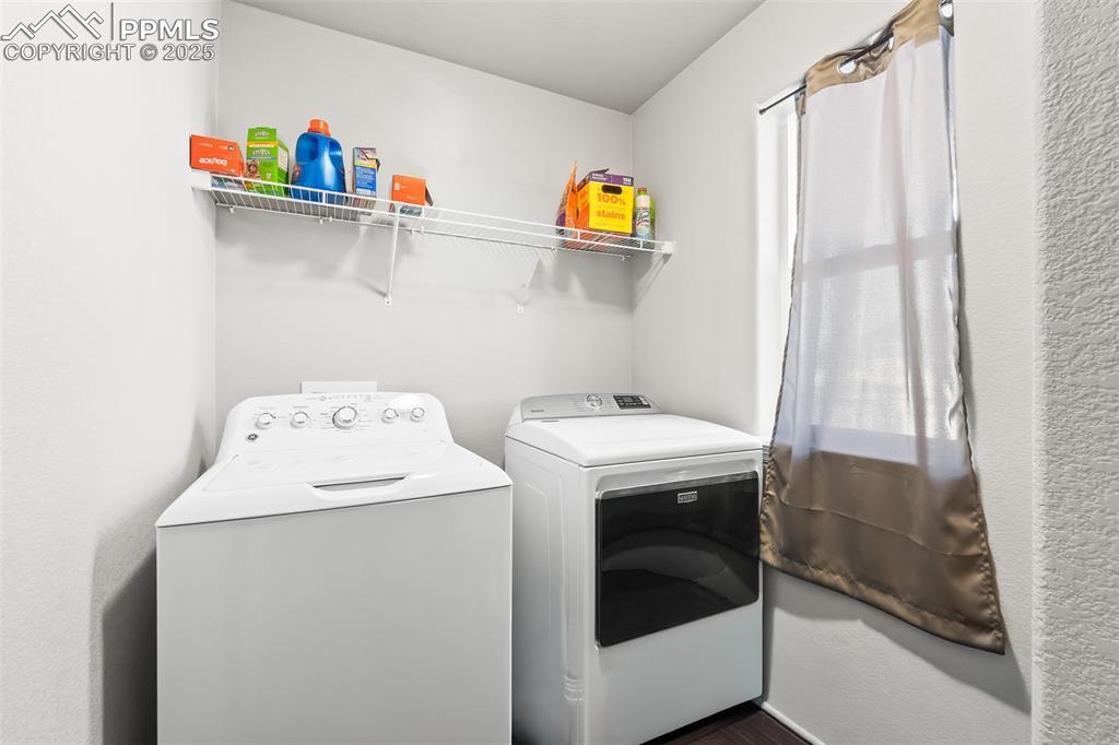Image 39 of 48: Laundry area with washing machine and dryer and dark wood-type flooring