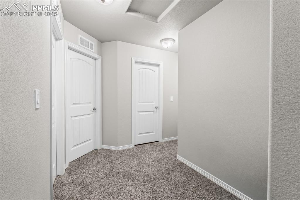 Image 40 of 48: Hallway featuring carpet floors and a textured wall