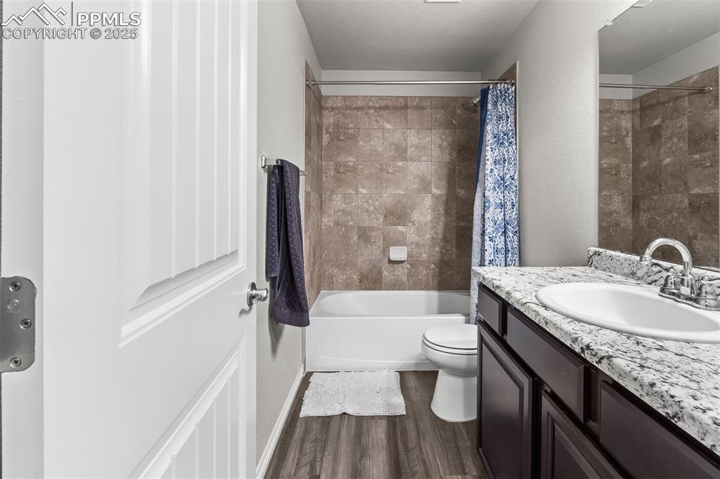 Image 45 of 48: Full bathroom with shower / bath combo, vanity, and dark wood-style floorin