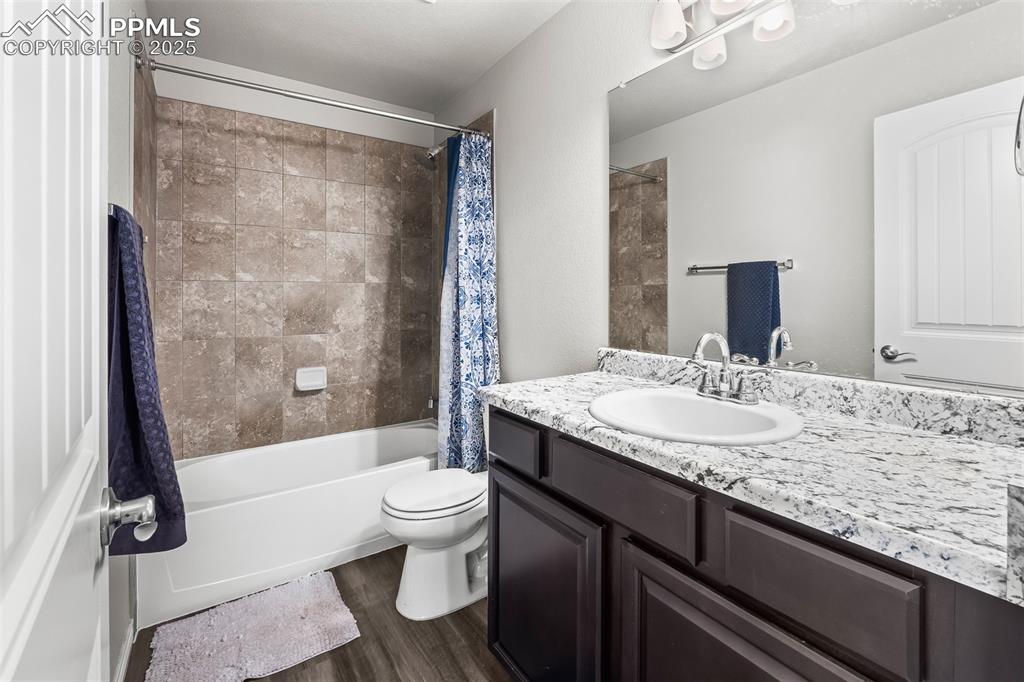 Image 46 of 48: Full bath with dark wood-style floors, shower / bath combination with curta