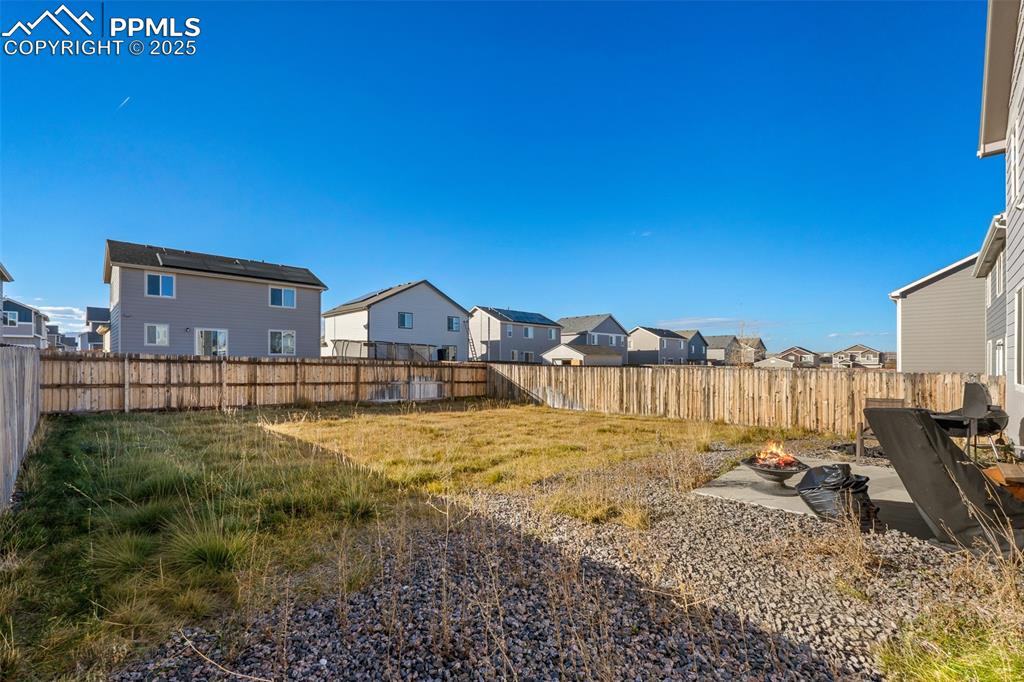 Image 8 of 48: Fenced backyard featuring a patio area, a residential view, and a fire pit