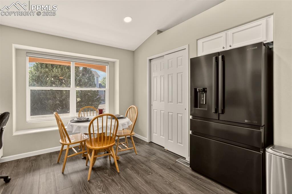 Image 14 of 38: Dining space with dark wood-style LVP flooring and recessed lighting
