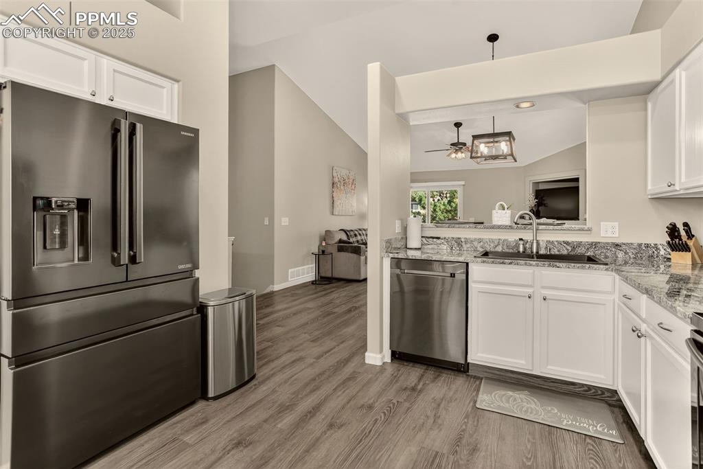 Image 15 of 38: Kitchen featuring appliances with stainless steel finishes, white cabinetry