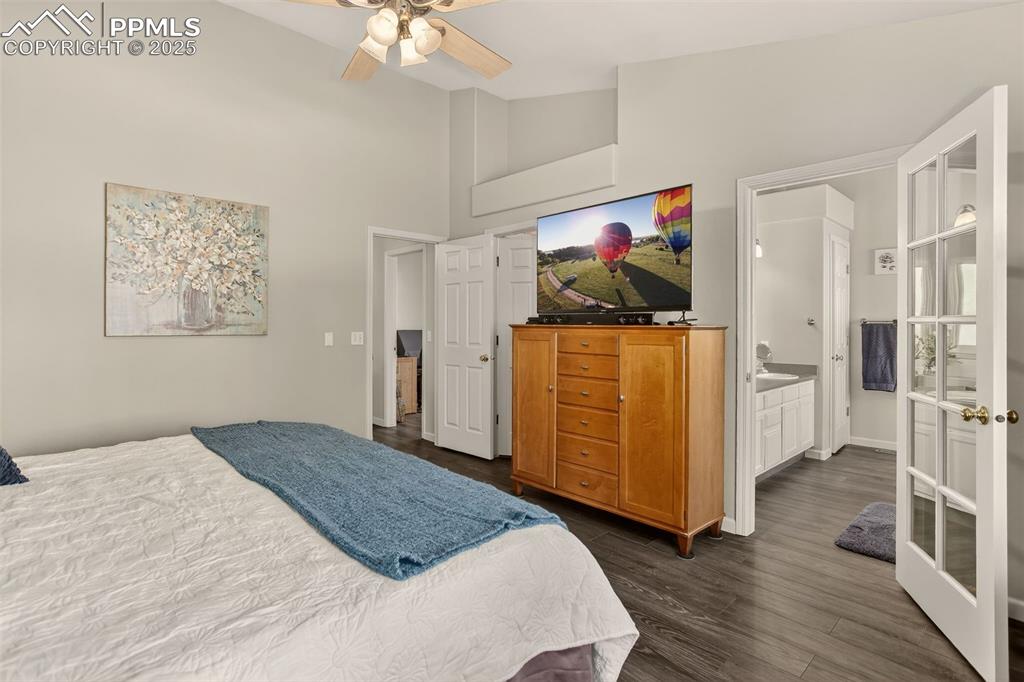 Image 20 of 38: Bedroom with high vaulted ceiling, dark wood-type flooring, and a ceiling f