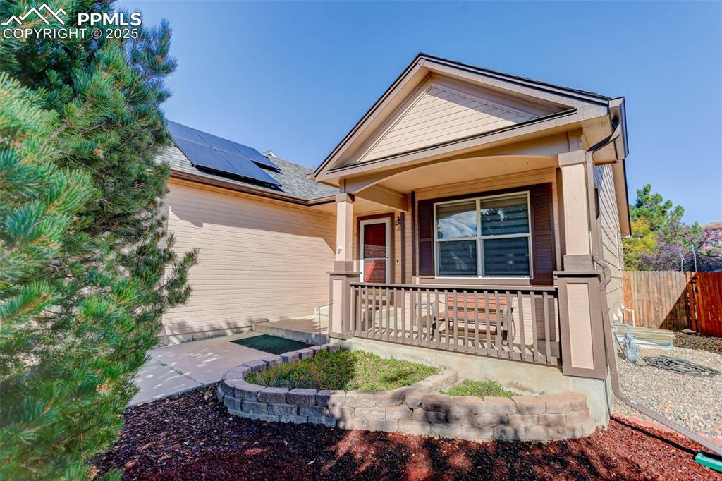 Image 3 of 38: View of front of property featuring roof mounted solar panels and a porch
