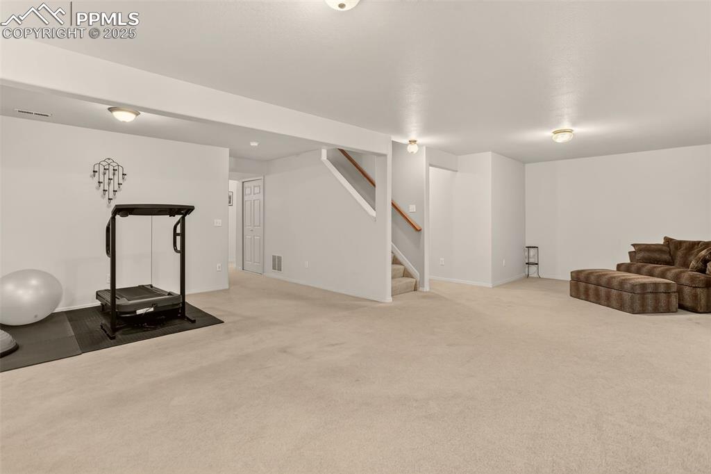 Image 33 of 38: Exercise area featuring light carpet and baseboards
