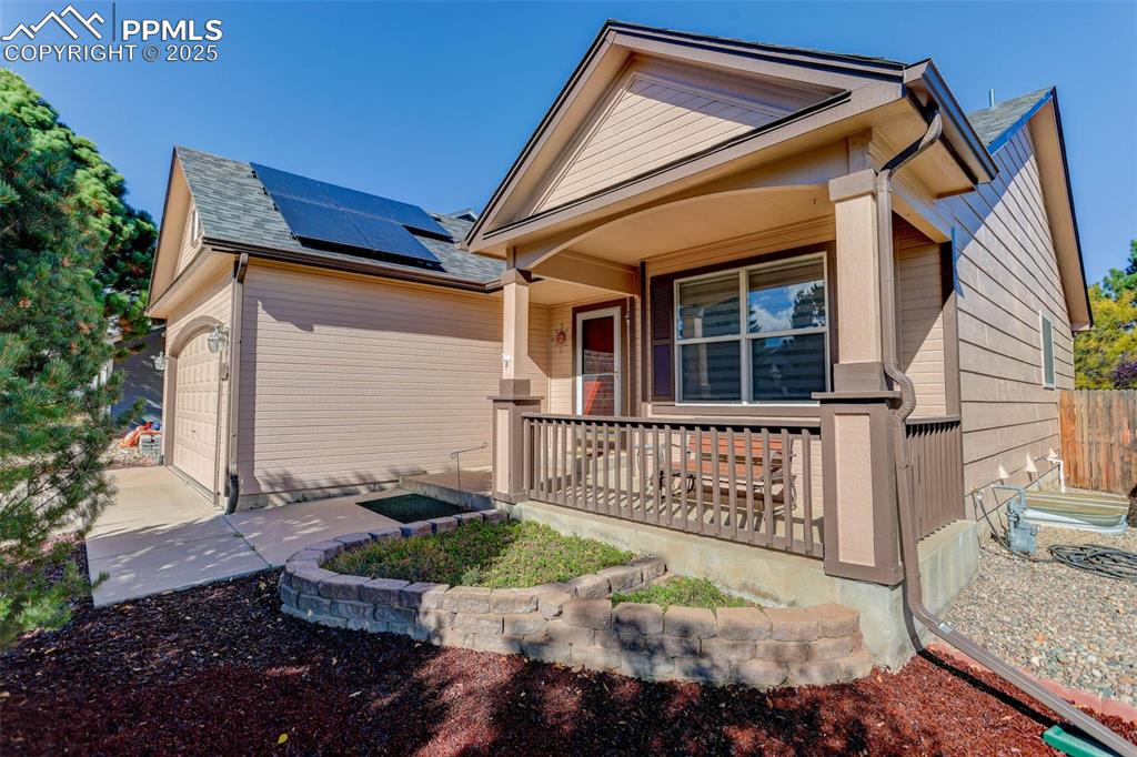 Image 4 of 38: View of front of property with roof mounted solar panels, covered porch, an
