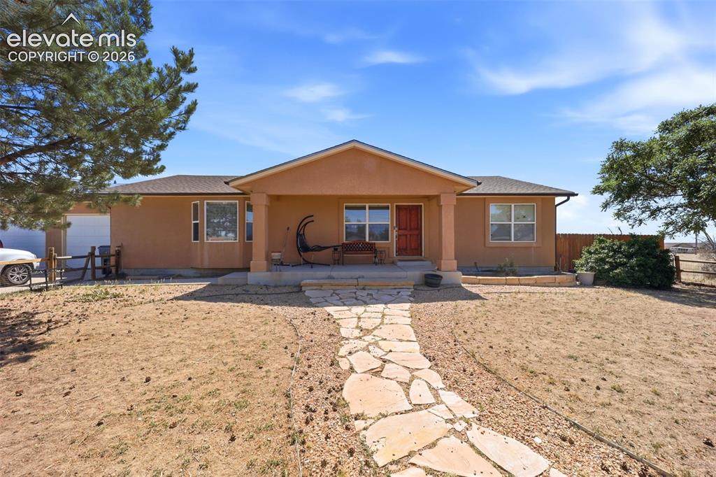 Image 1 of 49: Southwestern style residence featuring a covered front porch, stucco exteri