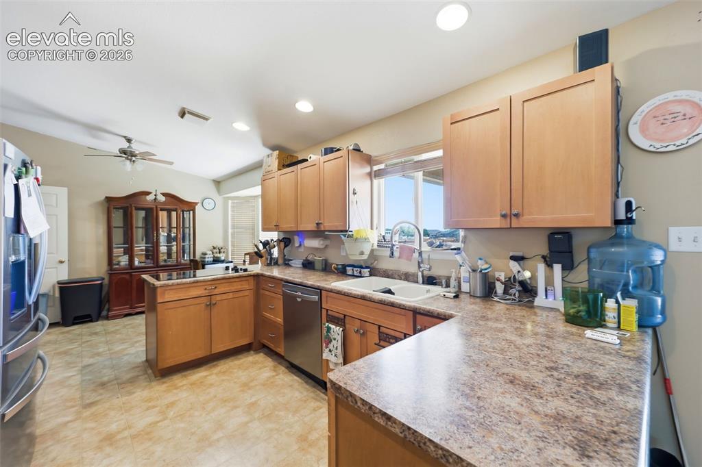 Image 10 of 49: Spacious kitchen featuring light wood cabinetry, a double basin sink, stain