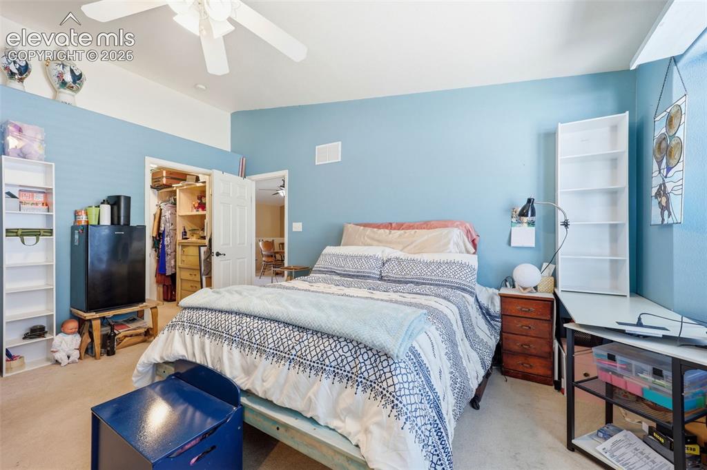 Image 14 of 49: Carpeted bedroom featuring a ceiling fan, light blue walls, and a recessed