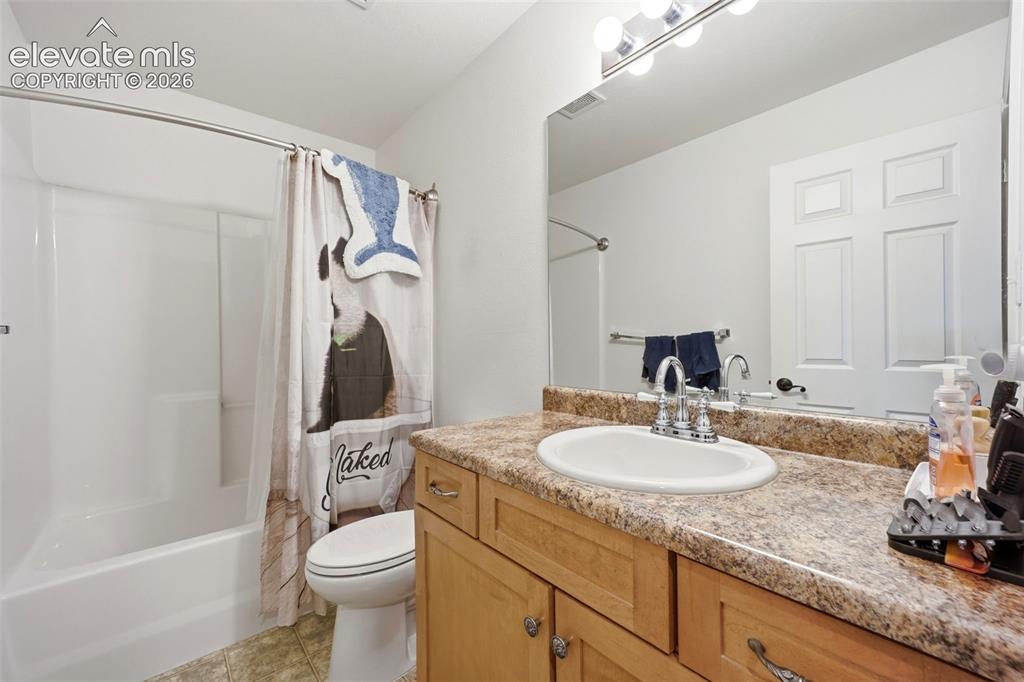 Image 22 of 49: Bathroom featuring a full vanity with an integrated sink, a large mirror, a
