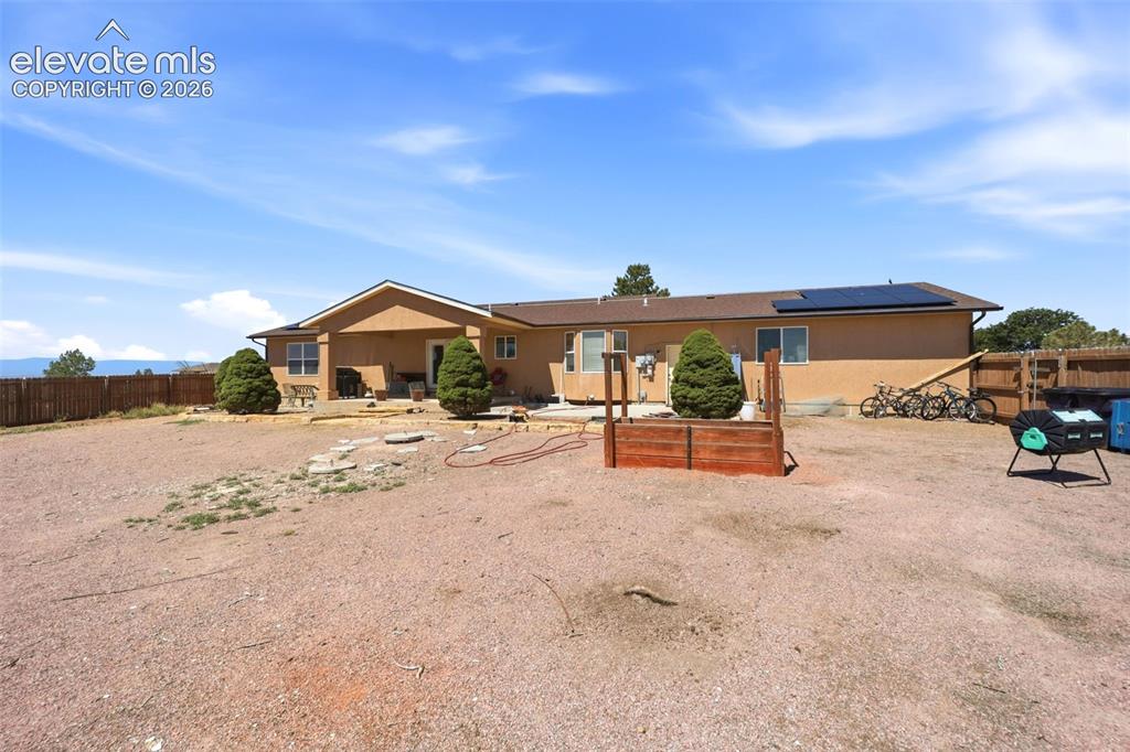 Image 36 of 49: South-facing stucco exterior with a composite shingle roof, integrated sola