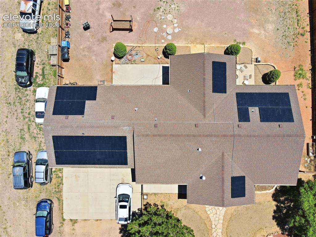 Image 49 of 49: Gable roof home featuring multiple solar panel arrays, a concrete driveway,