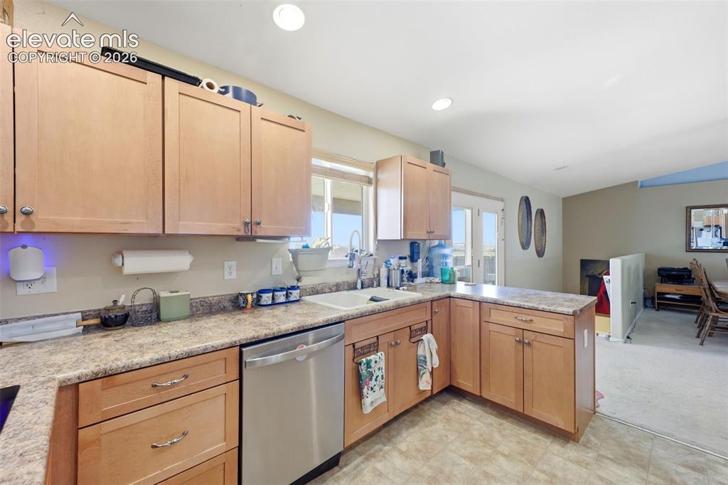Image 8 of 49: Kitchen featuring light wood cabinetry, a stainless steel dishwasher, a sin