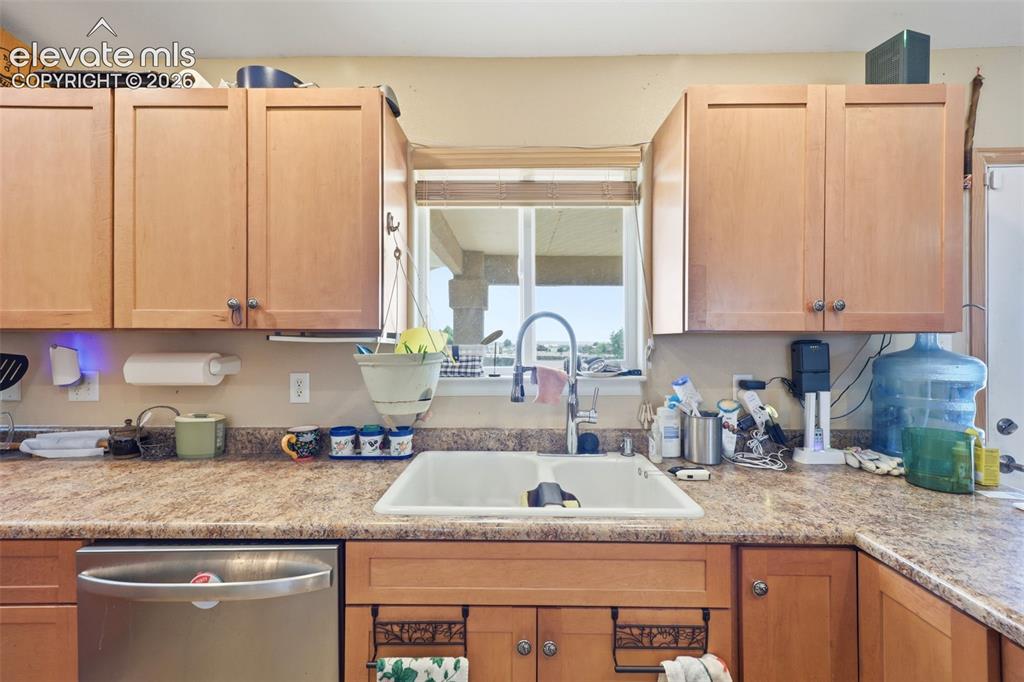 Image 9 of 49: Kitchen featuring light wood cabinetry, a double basin sink with a high-arc