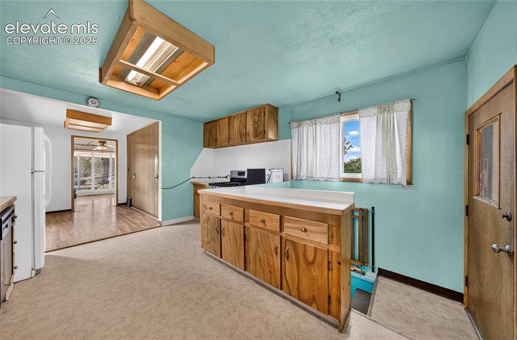 Image 11 of 45: Kitchen featuring wood cabinetry, white countertops, a built-in oven, and o