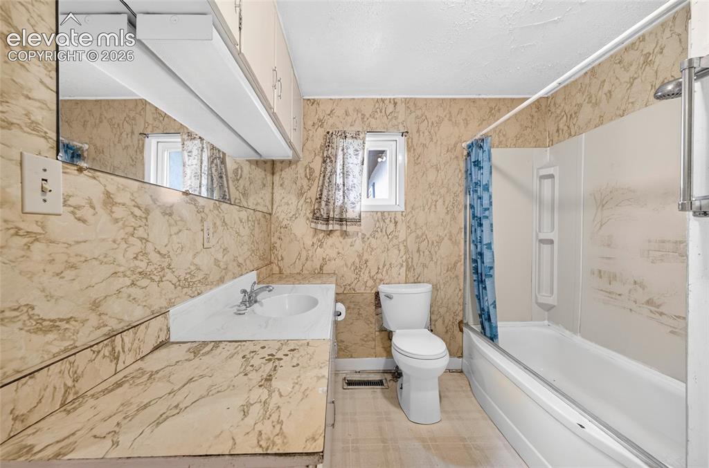 Image 15 of 45: Vanity with integrated sink, wall-mounted mirror, overhead lighting fixture