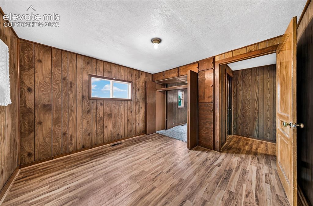 Image 20 of 45: Spacious interior featuring warm wood-finish paneling throughout, wood-fini