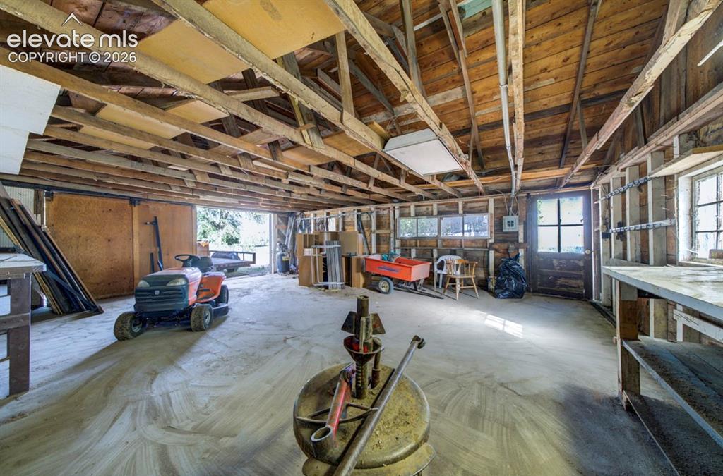 Image 34 of 45: Detached two-car garage with built-in tire repair stand
