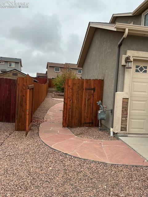 Image 2 of 29: View of property exterior with stucco siding left of the single garage door