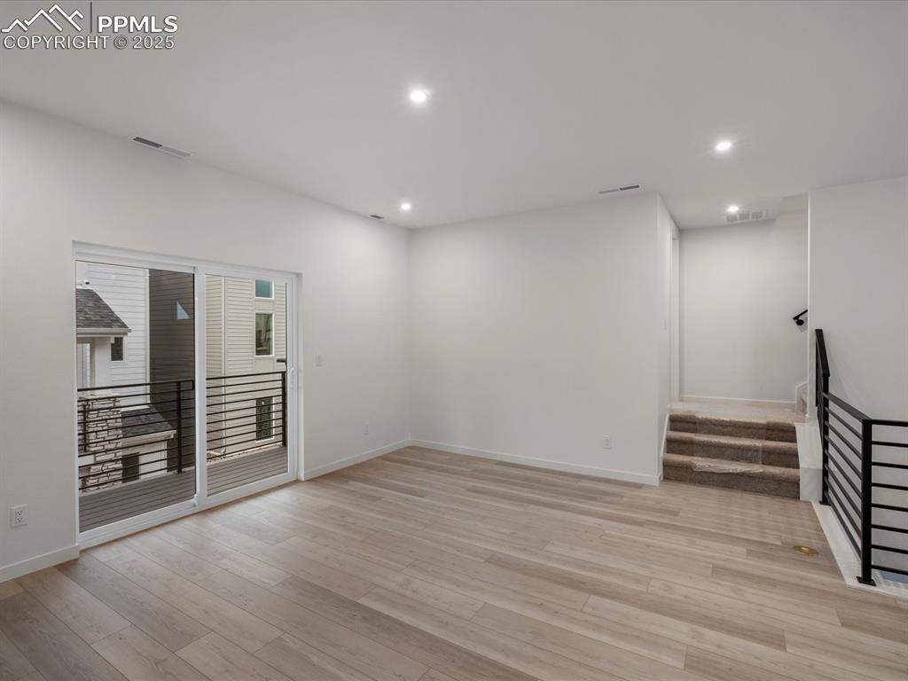 Image 14 of 32: Unfurnished room featuring stairs, recessed lighting, and light wood-type f