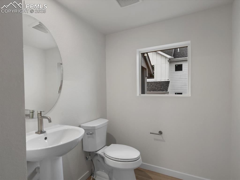 Image 15 of 32: Half bath featuring toilet and wood finished floors