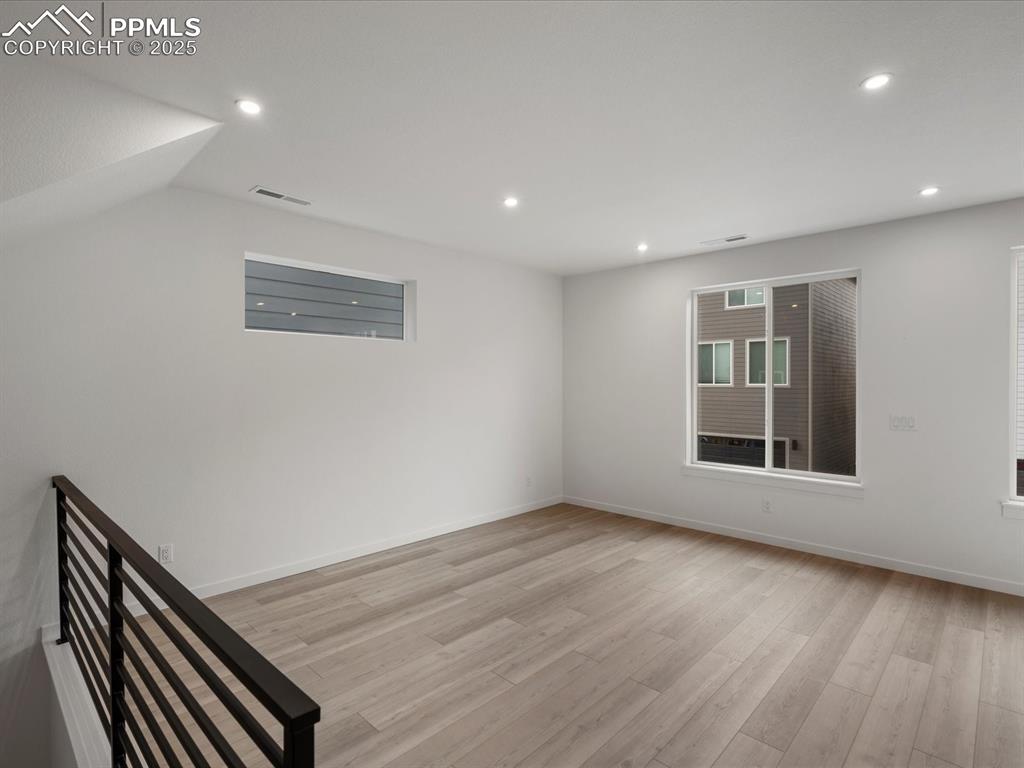 Image 29 of 32: Empty room featuring light wood finished floors and recessed lighting