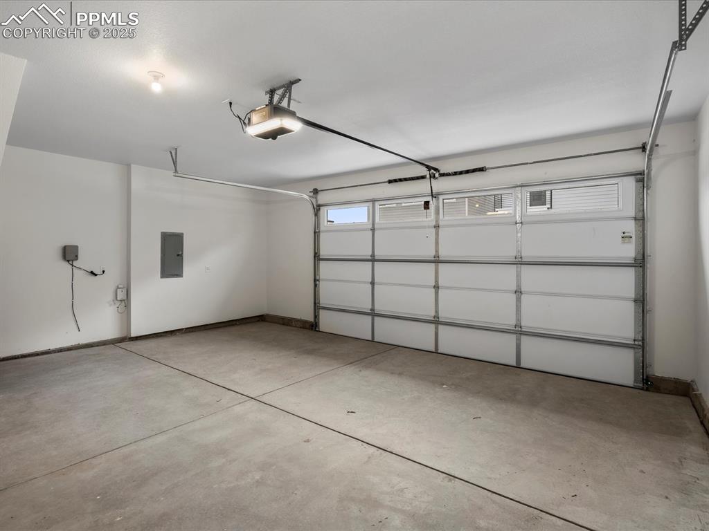 Image 32 of 32: Garage with electric panel and a garage door opener
