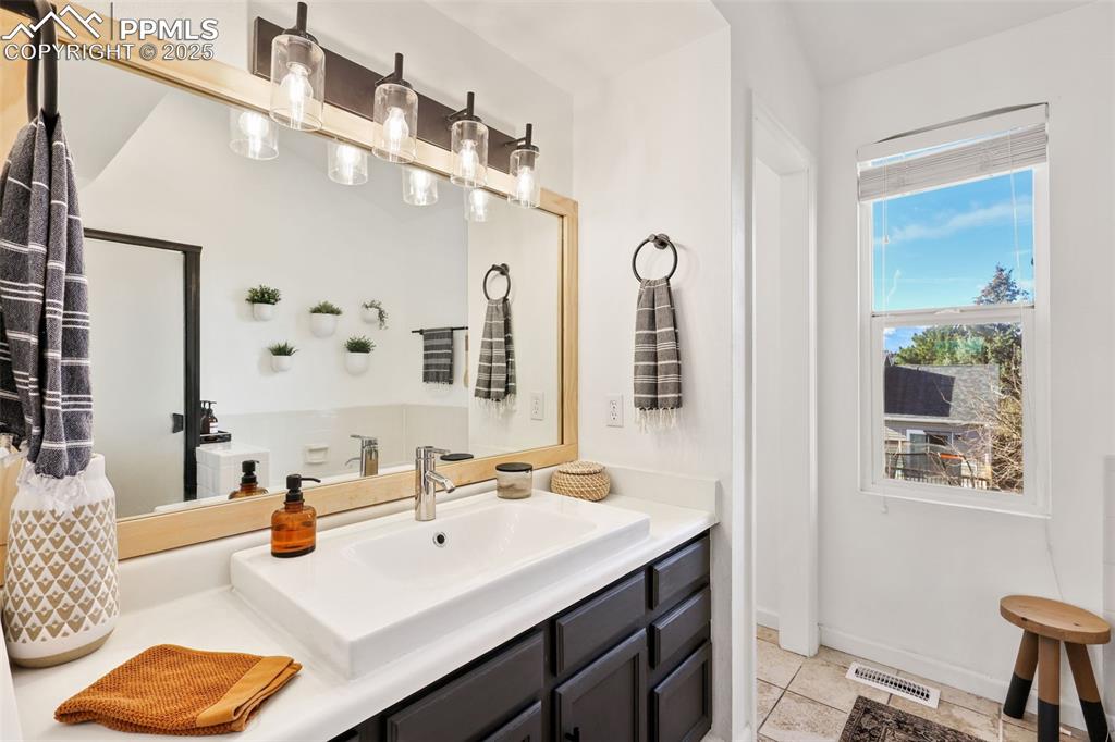 Image 16 of 27: Bathroom featuring vanity and light tile patterned floors