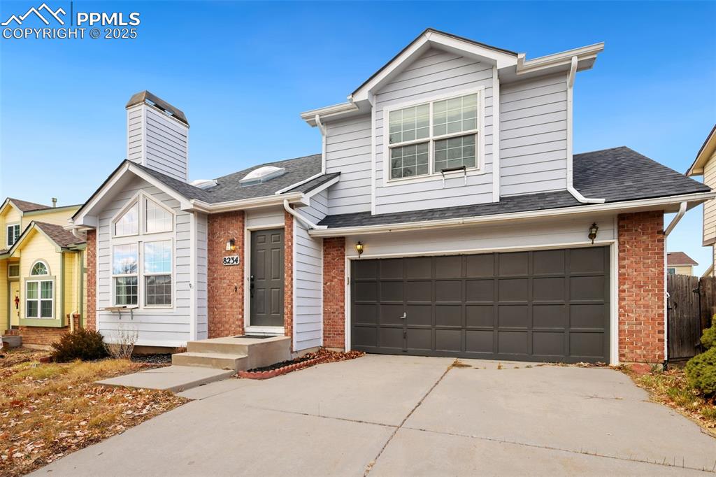 Image 2 of 27: Traditional-style home with an attached garage, concrete driveway, a shingl