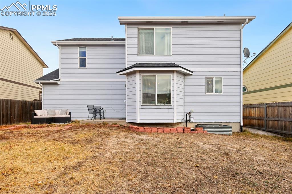 Image 27 of 27: Rear view of house with a fenced backyard and an outdoor living space