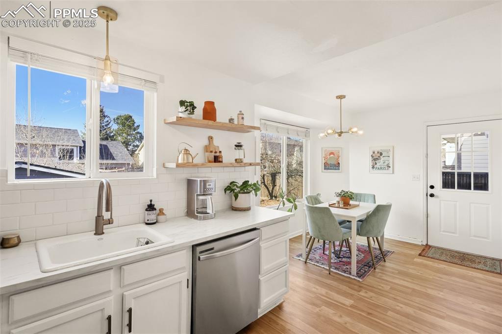 Image 7 of 27: Kitchen featuring pendant lighting, stainless steel dishwasher, white cabin