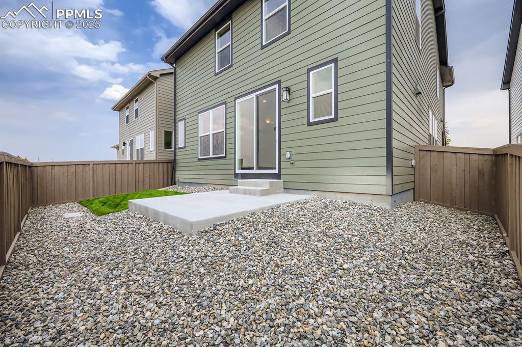 Image 28 of 28: Back of property with a fenced backyard and a patio